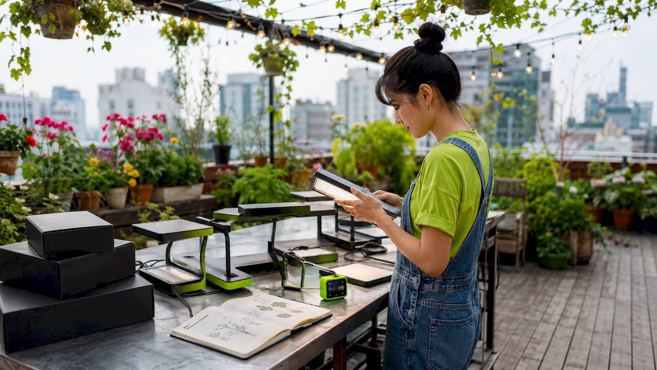 Gardener arranging micro grow light kits on balcony table