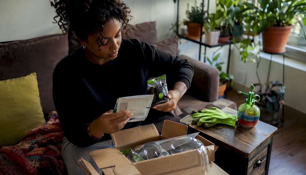 Person unpacking indoor grow kit at home