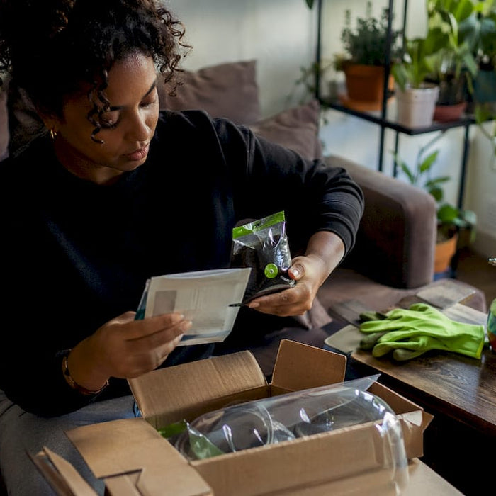 Person unpacking indoor grow kit at home